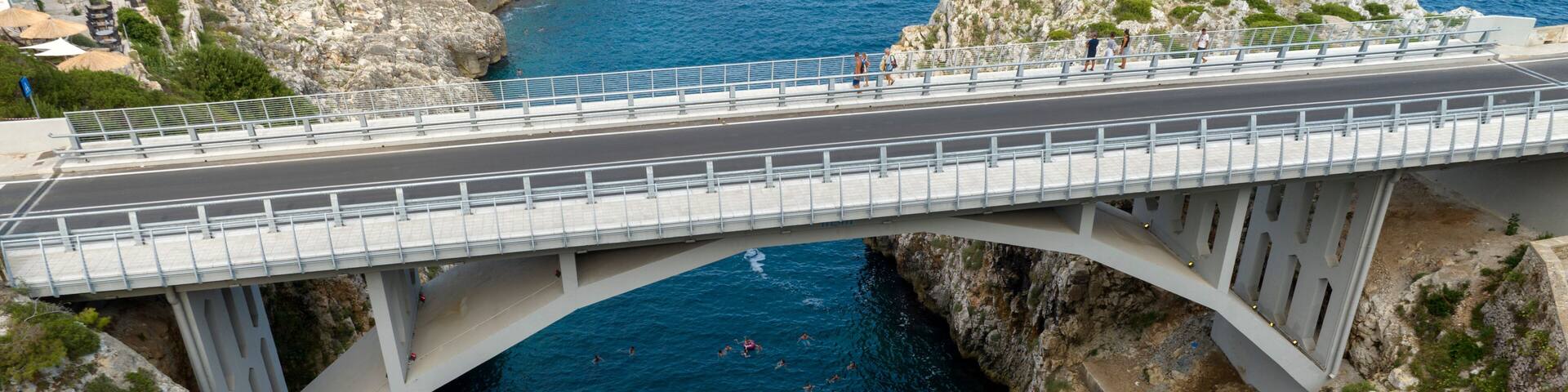 Aerial view of Ciolo's Bridge in the province of Lecce, Salento, Puglia, Italy. It is a single-span bridge and crosses a inlet. It overlooks the Mediterranean Sea.