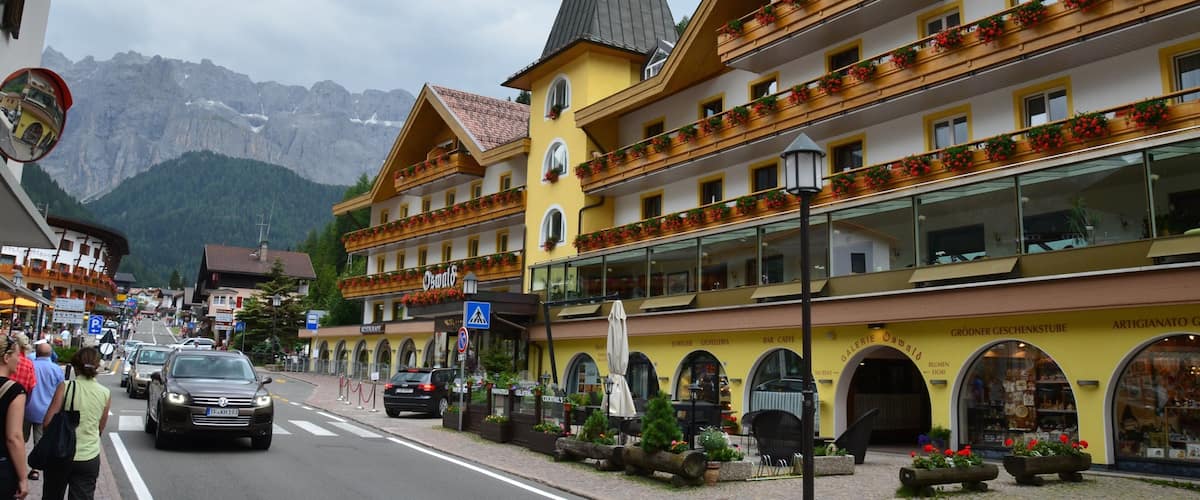 A street with buildings, cars, and mountains in the background.
