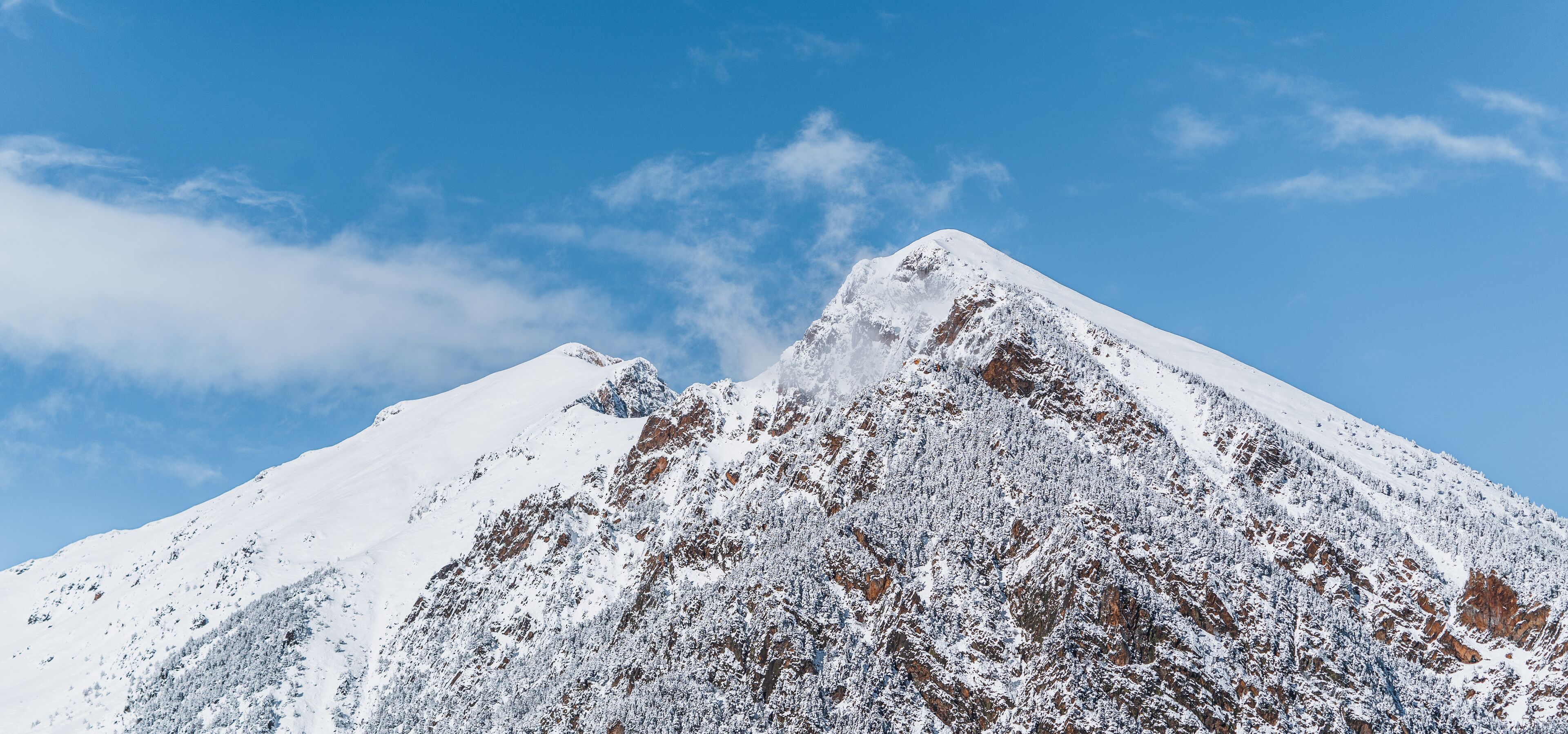 Panoramic view of snowy mountains. Abundance of snow that covers the entire mountain range. Sunny winter scenery. Tourism in Spain, Catalonia, Pyrenees, Ripollés, Vallter, Setcases, Gra de Fajol.