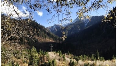 Um lago de montanha límpido rodeado por colinas arborizadas.