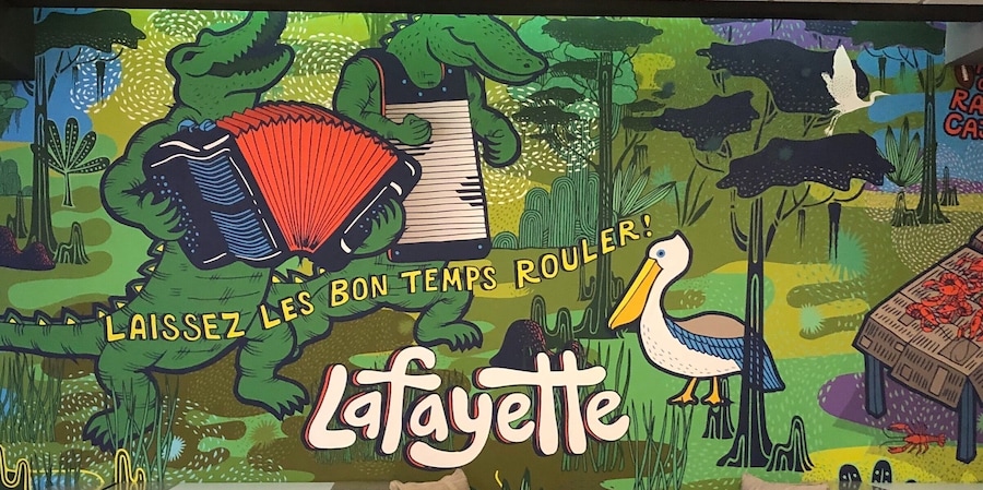 Una ilustración colorida de un cocodrilo, un pelícano y un libro con el texto 'Laissez les bon temps rouler!' y 'La Fayette'.
