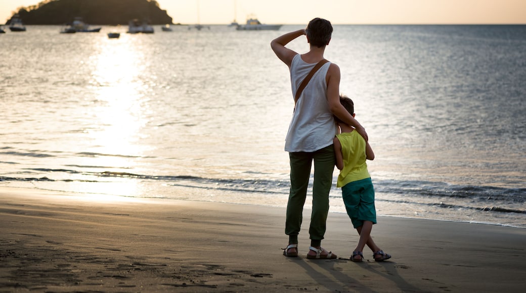 Mother and son looking the ocean from a beach at sunset. Concept of love and vacation. Playa del Coco, Costa Rica.
