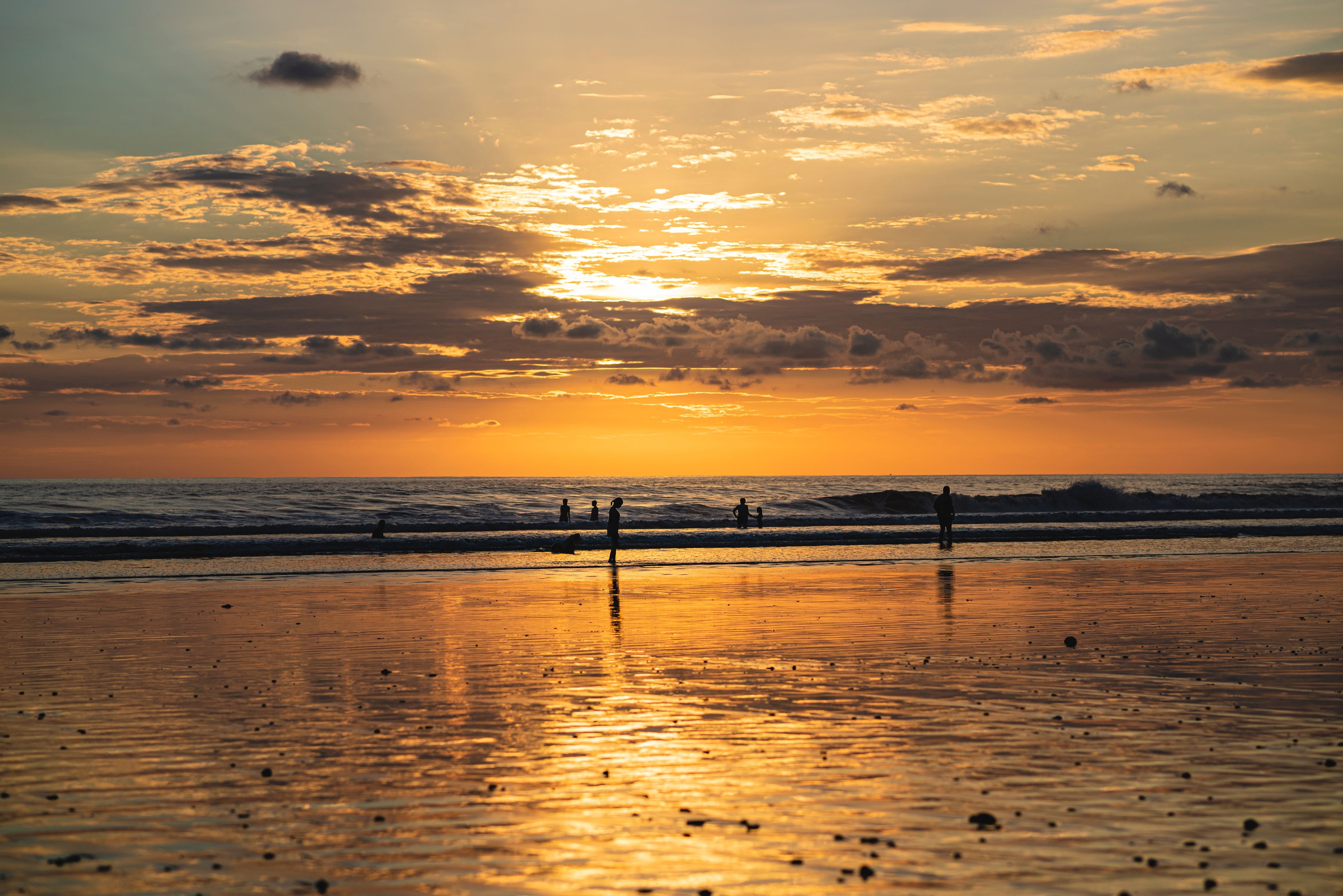 beautiful sunset on a beach in costa rica with unrecognizable people silhouettes, Playa hermosa
