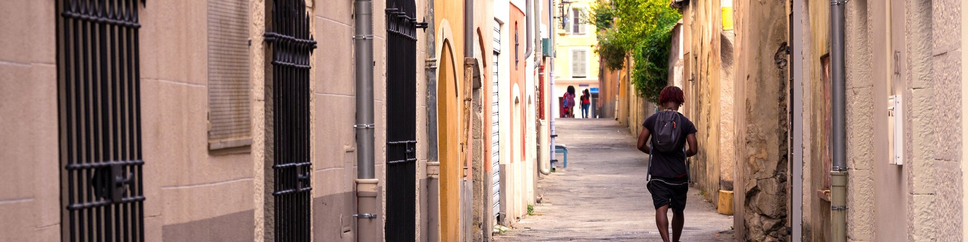 Backside view of a man walking along a mediterranean alley in Vallauris, Cote d'Azur