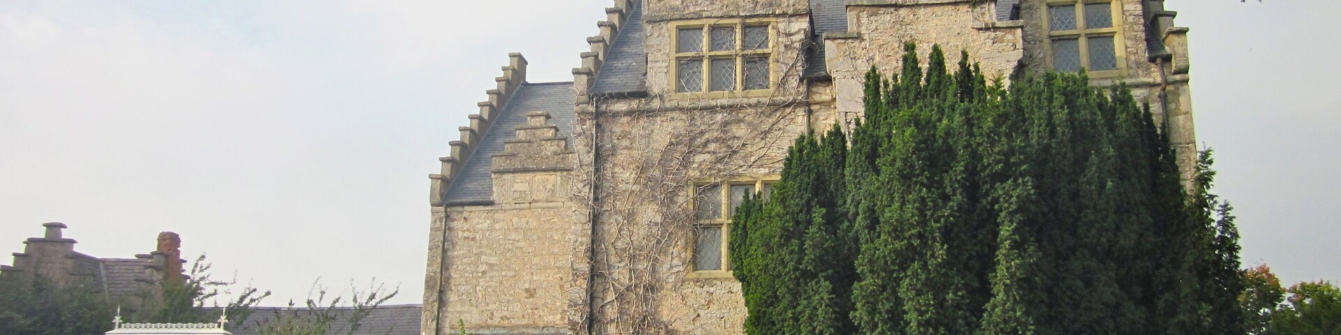 Un edificio grande de piedra con un techo empinado y varias chimeneas.