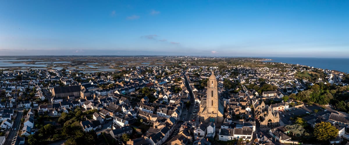 A coastal town with a prominent church, dense residential area, and a view of the sea.