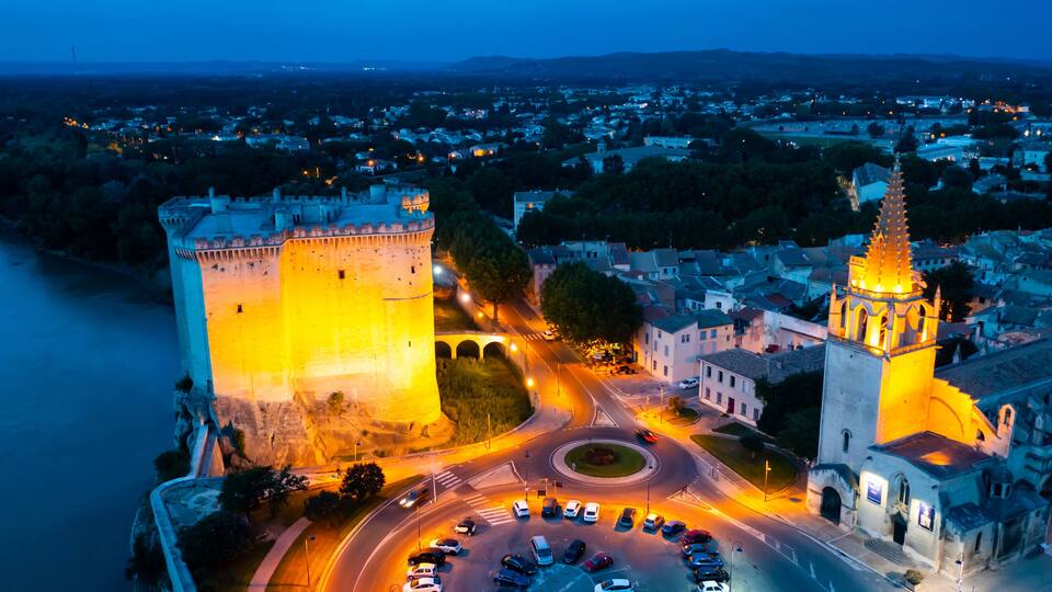 Aerial photo of Tarascon Castle along the Rhone River in evening, Tarascon, France.