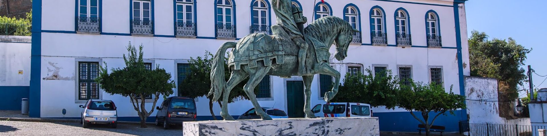 The statue of Nuno Alvarez Pereira is located in Portel in a small square in front of the castle entrance. Nuno is the legendary Portuguese hero who commanded the Portuguese army at the Battle of Aljubarrot, which ended in the defeat of the Castilians. This defeat made Juan I abandon claims to the Portuguese throne. In 1404, he donated his entire fortune to the Carmelite Monastery. After the death of his wife, he adjoins the Carmelite order and on August 15, 1423 he leaves for the monastery. There he lived until his death. The veneration of Nonia Alvarez-Pereira as a saint began immediately after his death. Among the people he was nicknamed the Holy Connable.