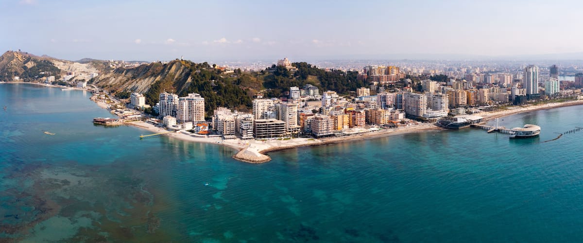 Scenic panoramic aerial view of Durres cityscape on Albanian Adriatic coast with wide landscaped beach promenade along seashore and Royal Villa