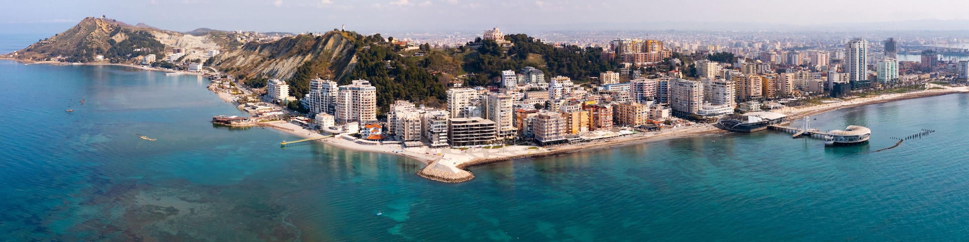 Scenic panoramic aerial view of Durres cityscape on Albanian Adriatic coast with wide landscaped beach promenade along seashore and Royal Villa