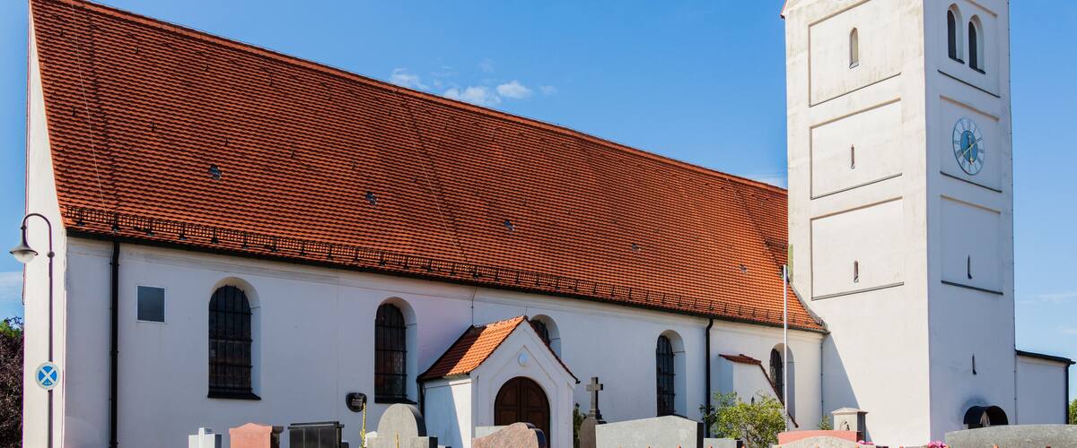 A church with a red-tiled roof and a clock tower.