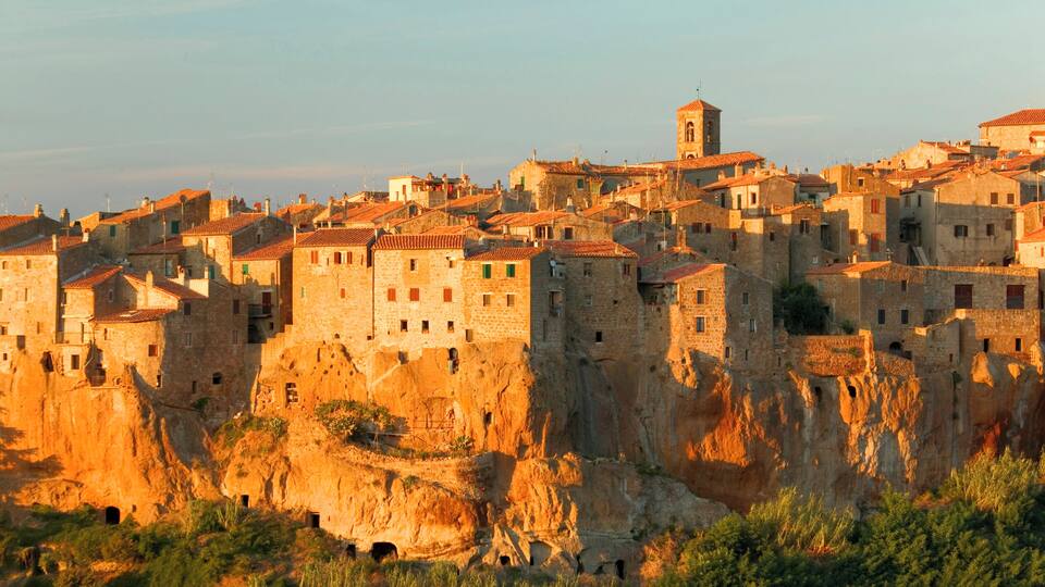 A historic town built on a cliff with stone buildings and a church.