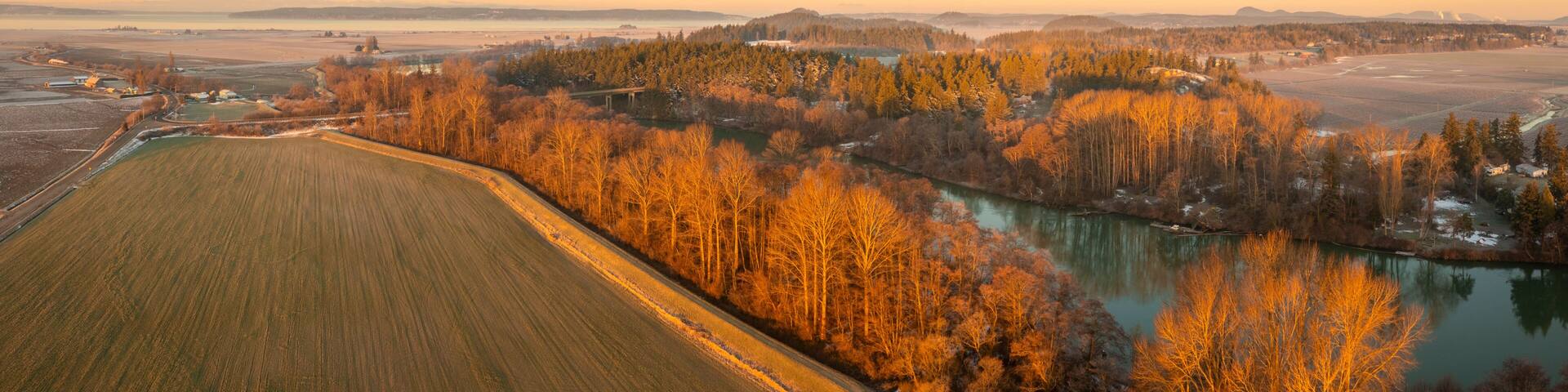 Aerial View of the Skagit River During a Brilliant Sunrise. The Skagit River runs from high in the Cascade Mountains to Puget Sound. The Skagit floodplain is one of the richest agricultural areas.