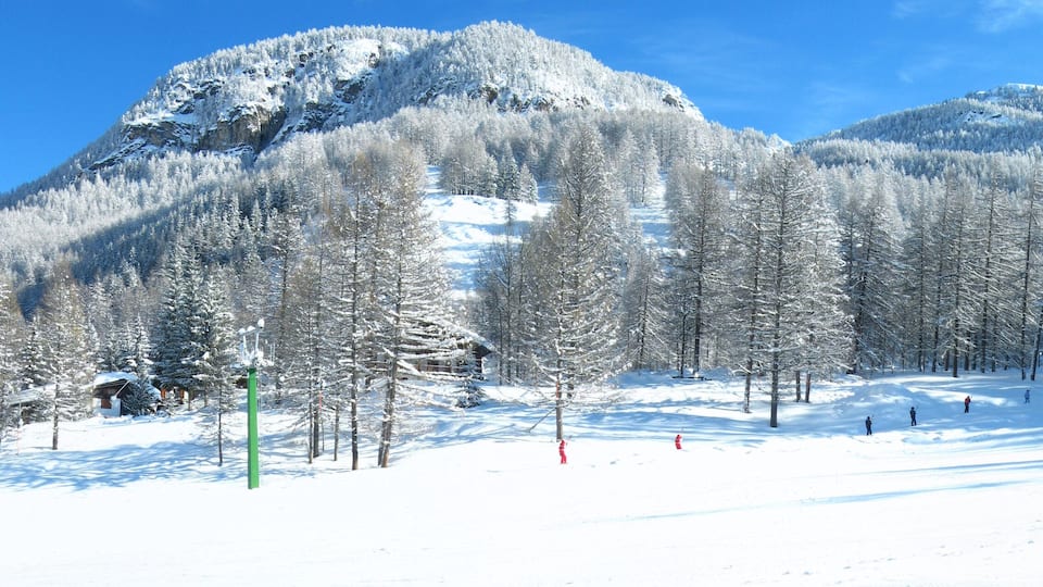 A snow-covered mountain with ski slopes and a lodge.