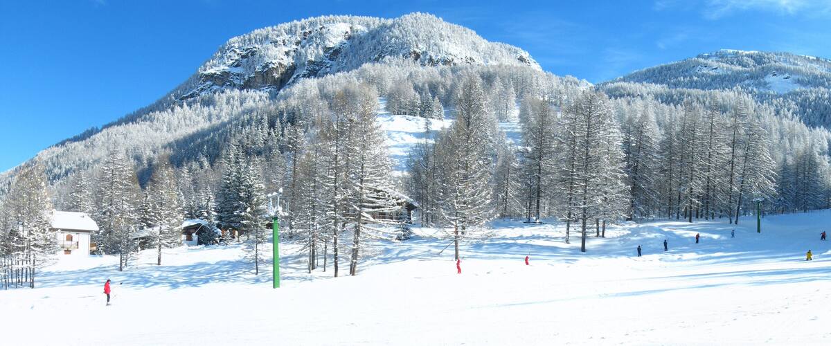 A snow-covered mountain with ski slopes and a lodge.