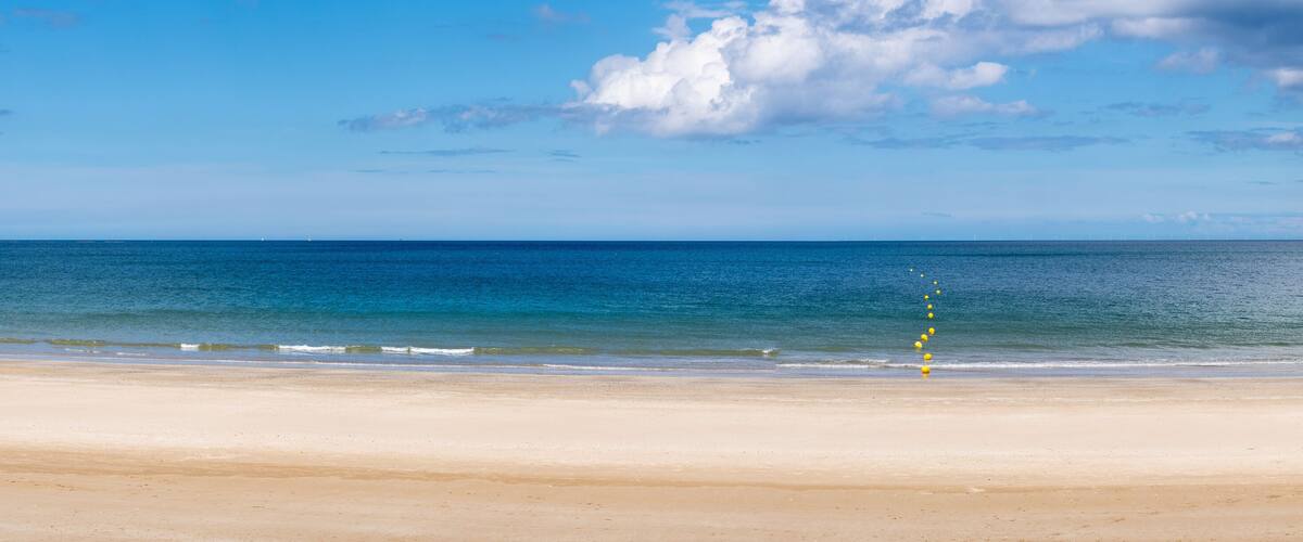 A beach with a clear sky and calm sea.