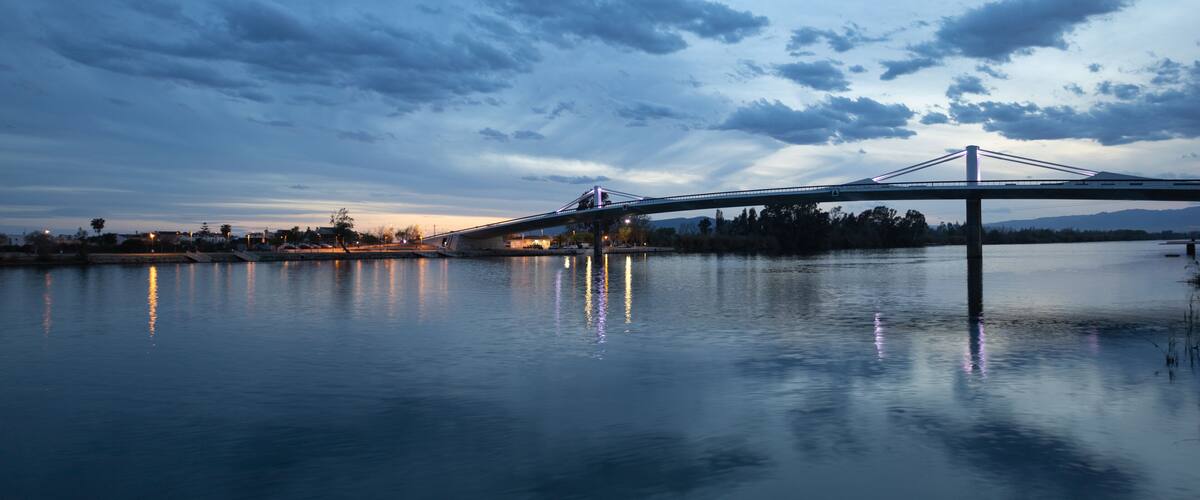 A bridge over calm water with a twilight sky.
