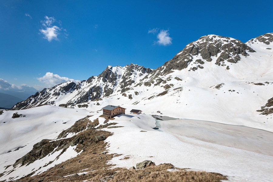 Terento, South Tyrol, Italy. The refuge Lago di Pausa / Tiefrastenhuette and the frozen lake