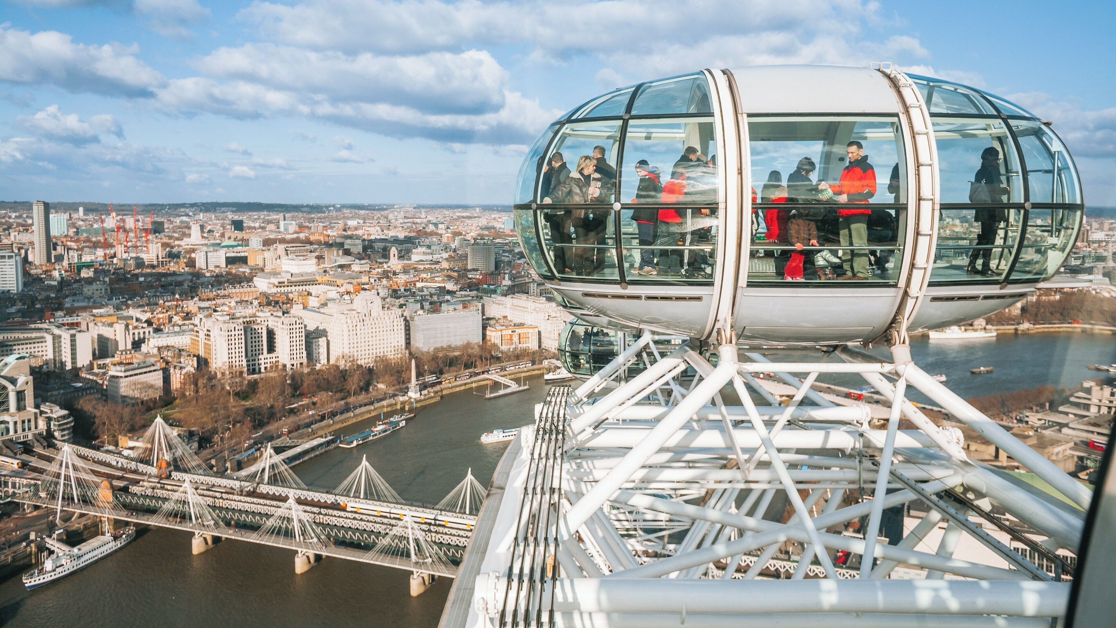 Views of the London Eye and cityscape of Lambeth, showcasing tourists enjoying a ride over the River Thames on a clear day