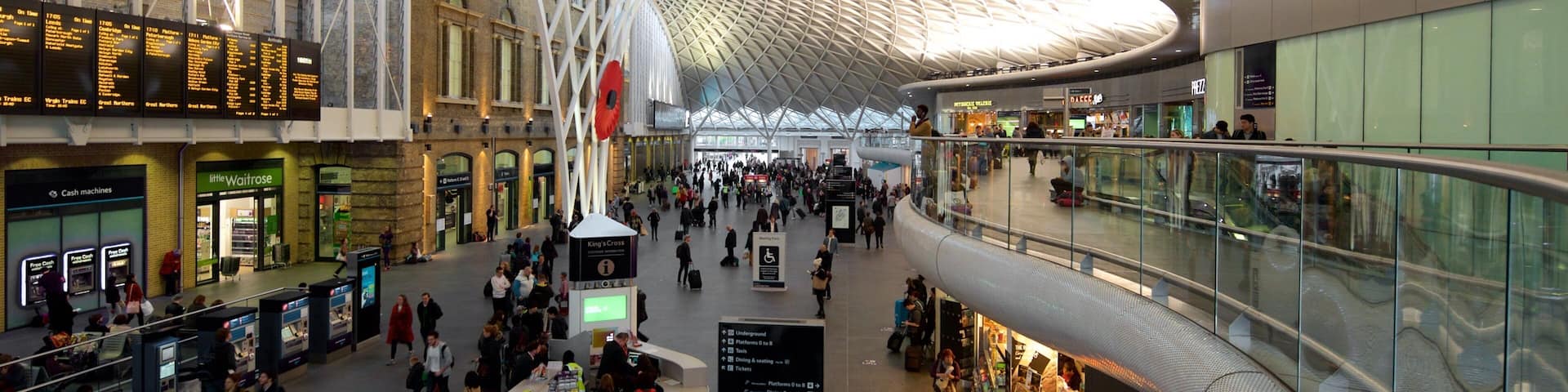 A spacious indoor area with a high, geometric ceiling and a glass facade.