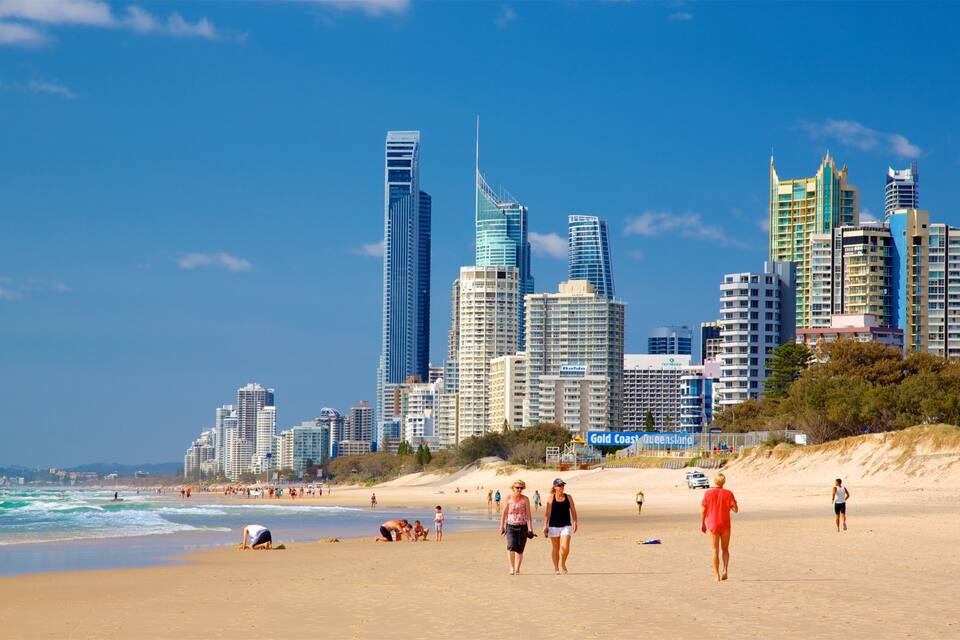 Una platja amb gent, un skyline urbà i l'oceà.