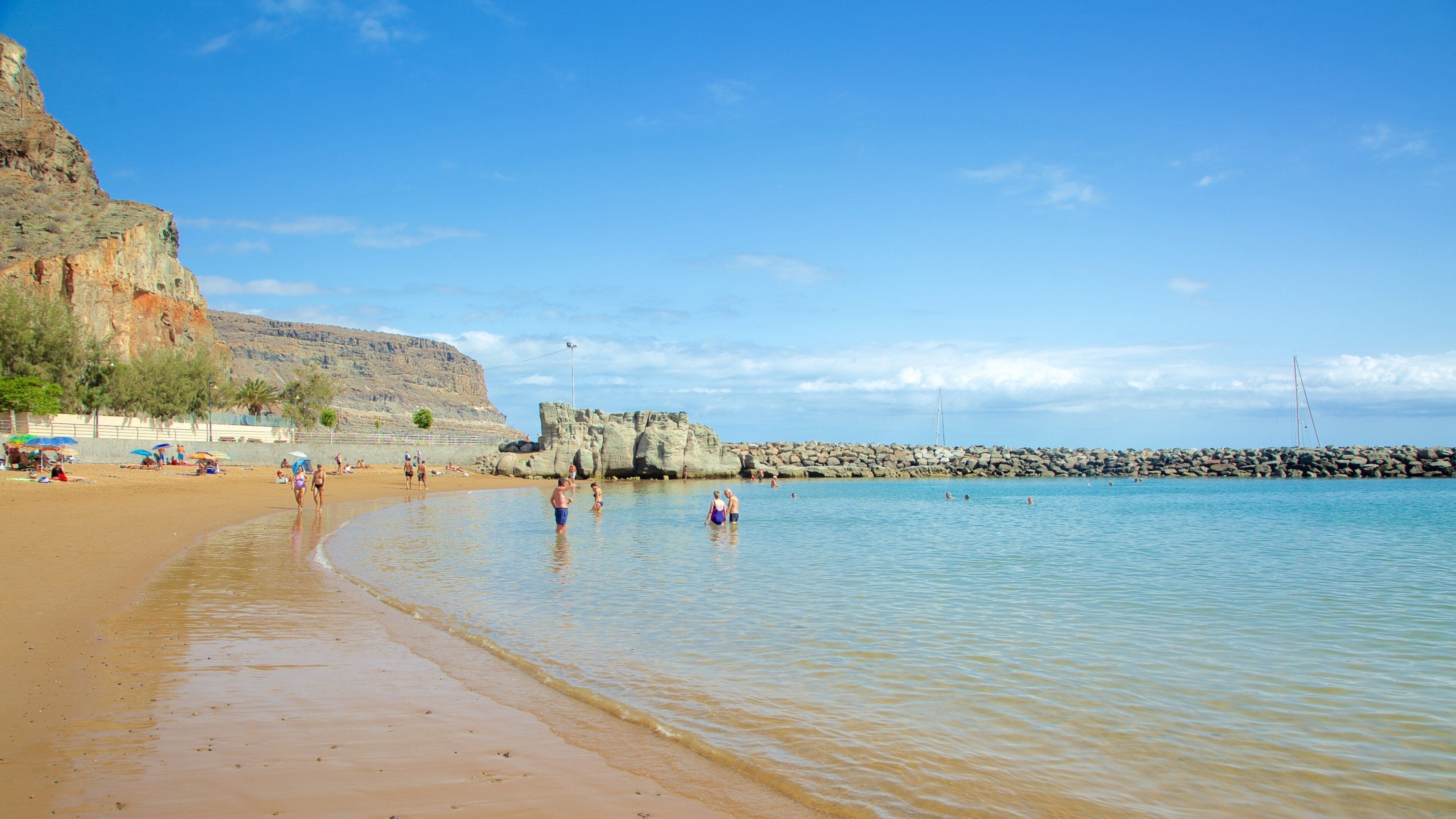 Mogán Beach which includes swimming, a sandy beach and general coastal views