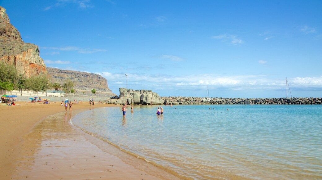 Mogán Beach which includes swimming, a sandy beach and general coastal views