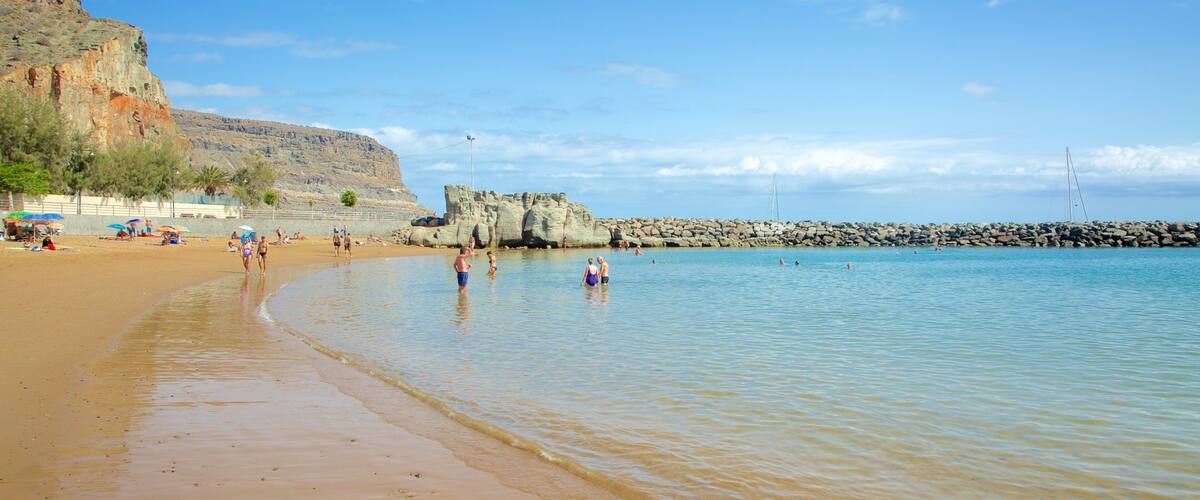 Mogán Beach which includes swimming, a sandy beach and general coastal views