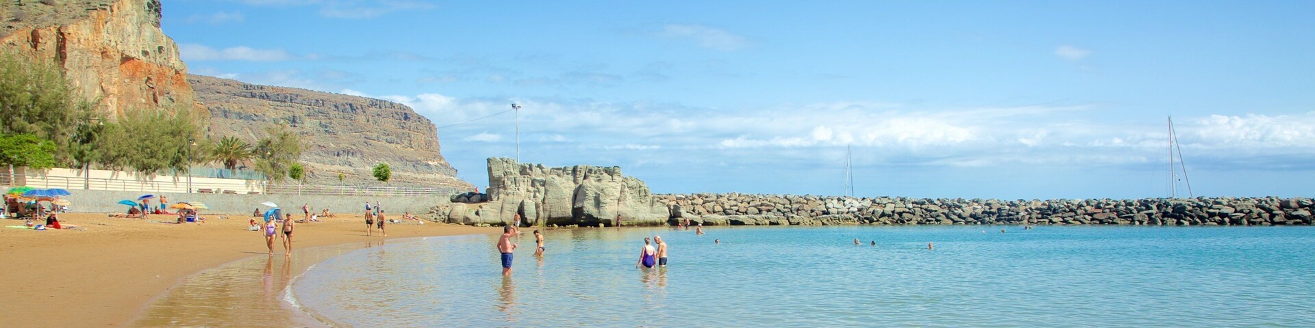 Mogán Beach which includes swimming, a sandy beach and general coastal views