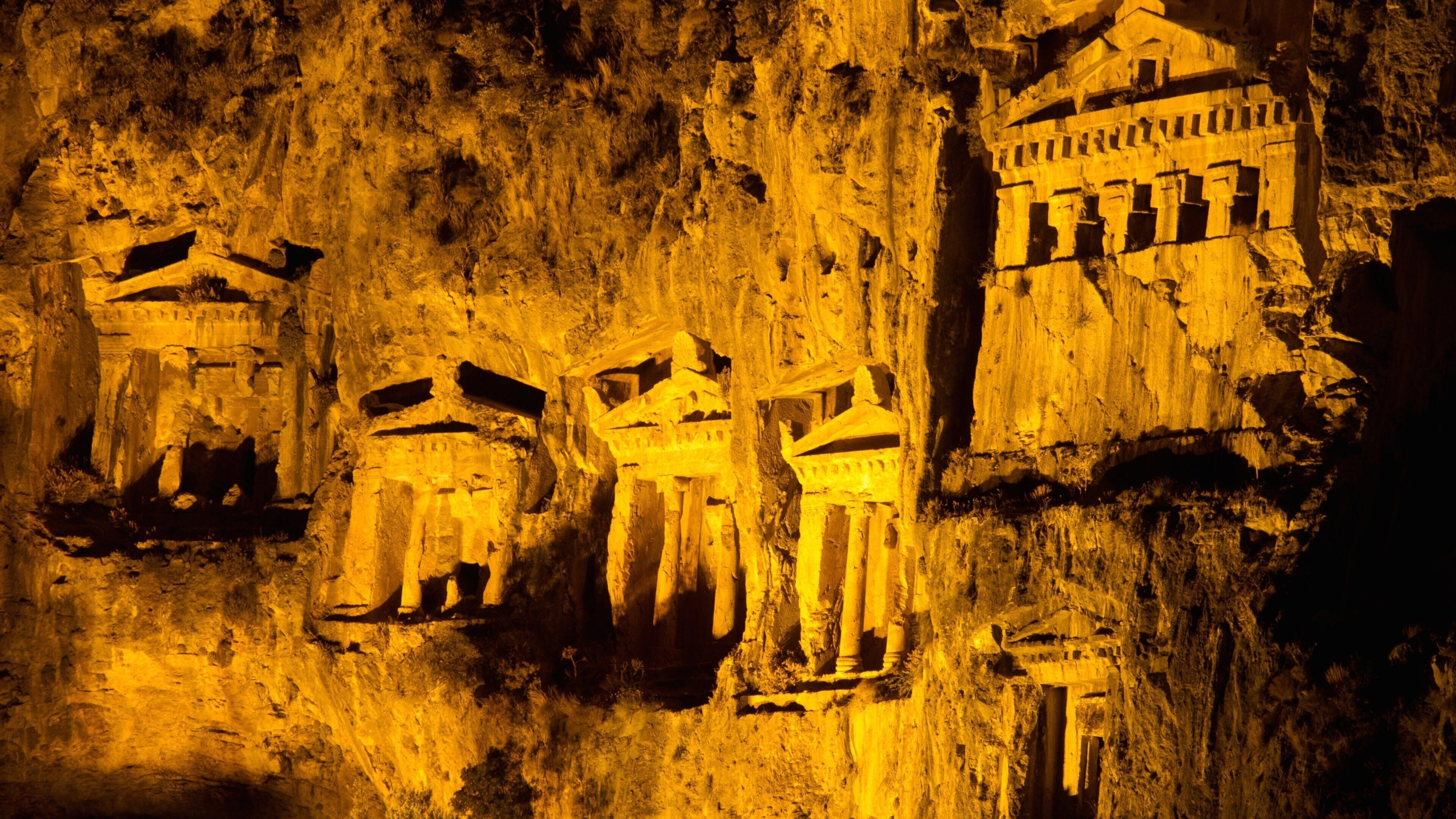 Ancient rock carvings of human figures and structures.