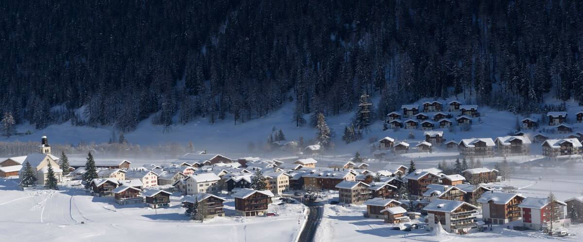 A snow-covered village with wooden houses and a church.