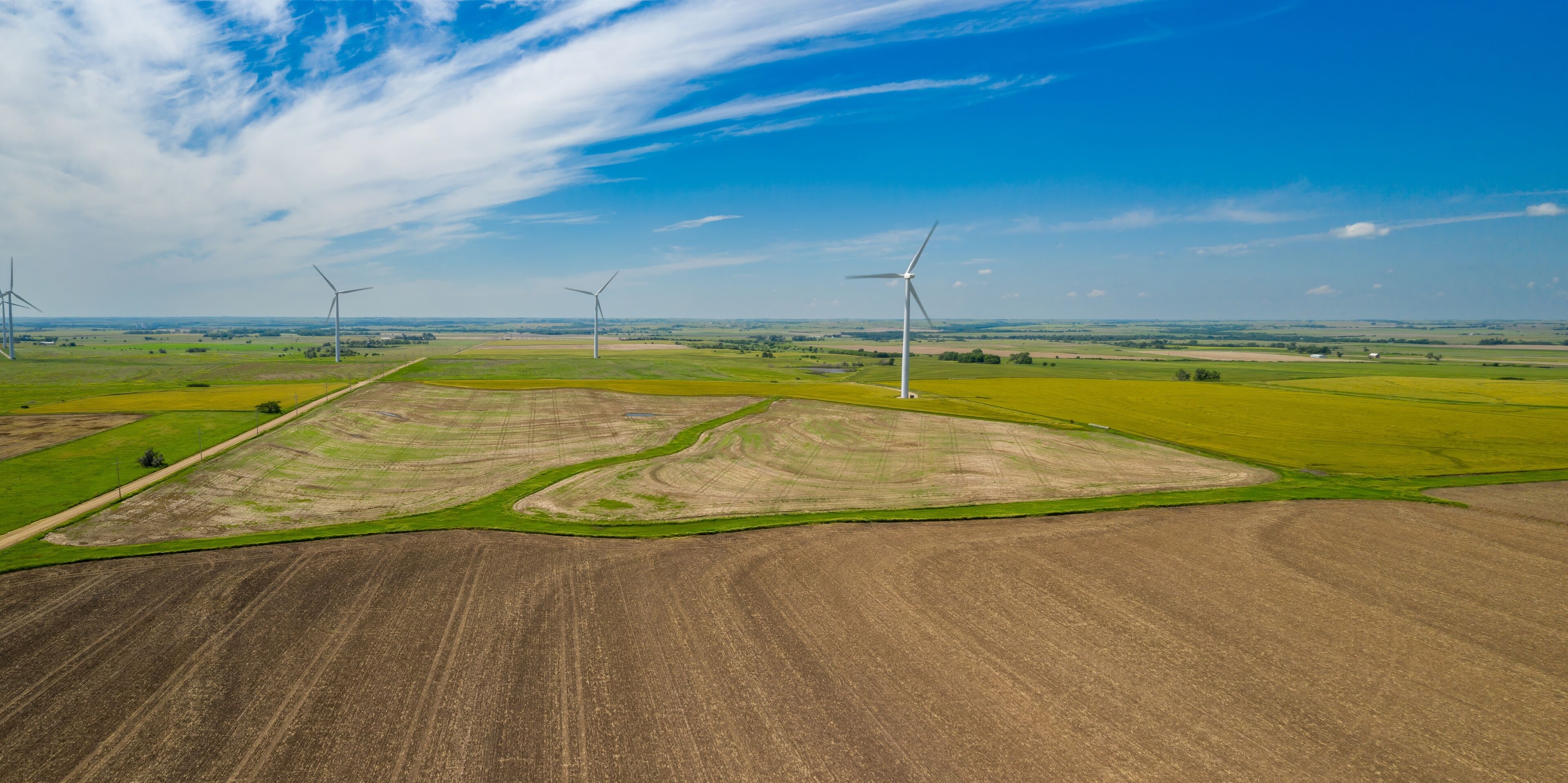 A landscape with wind turbines and agricultural fields.