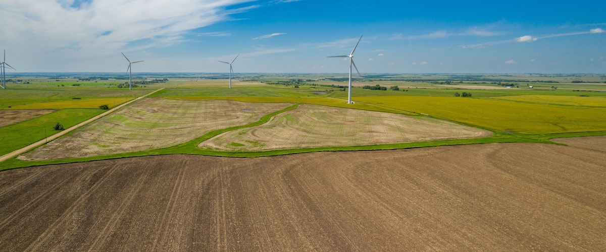 A landscape with wind turbines and agricultural fields.