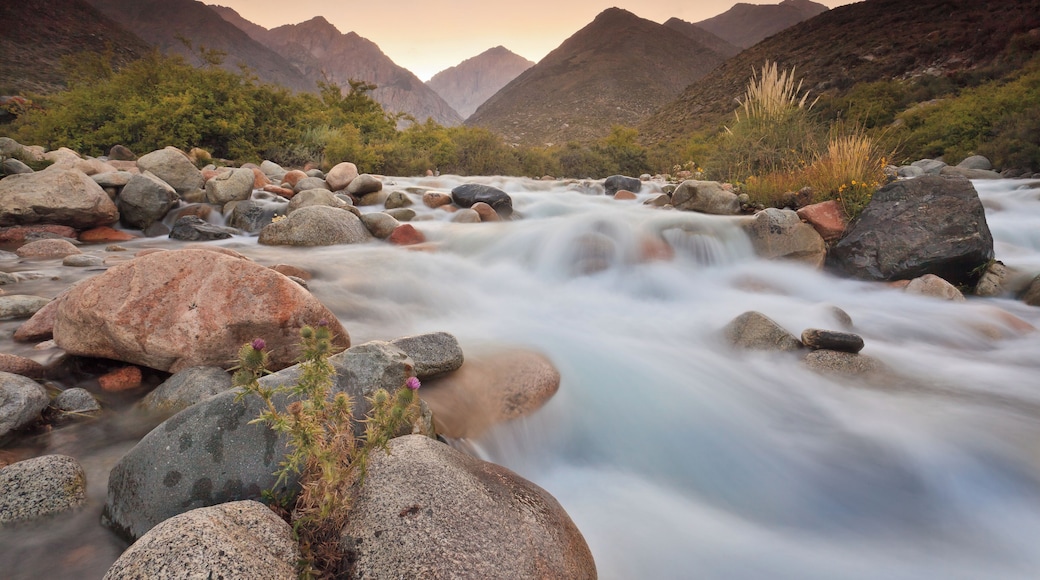 View of water stream at sunset with sun setting behind Andes Mountain rang located near Tunuyan, Mendoza, Argentina.