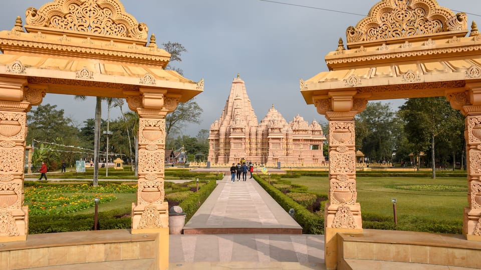 A temple with intricate carvings, a central pathway, and a well-maintained garden.