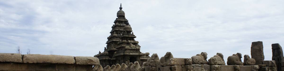 A stone temple with a tiered tower and stone lion statues.