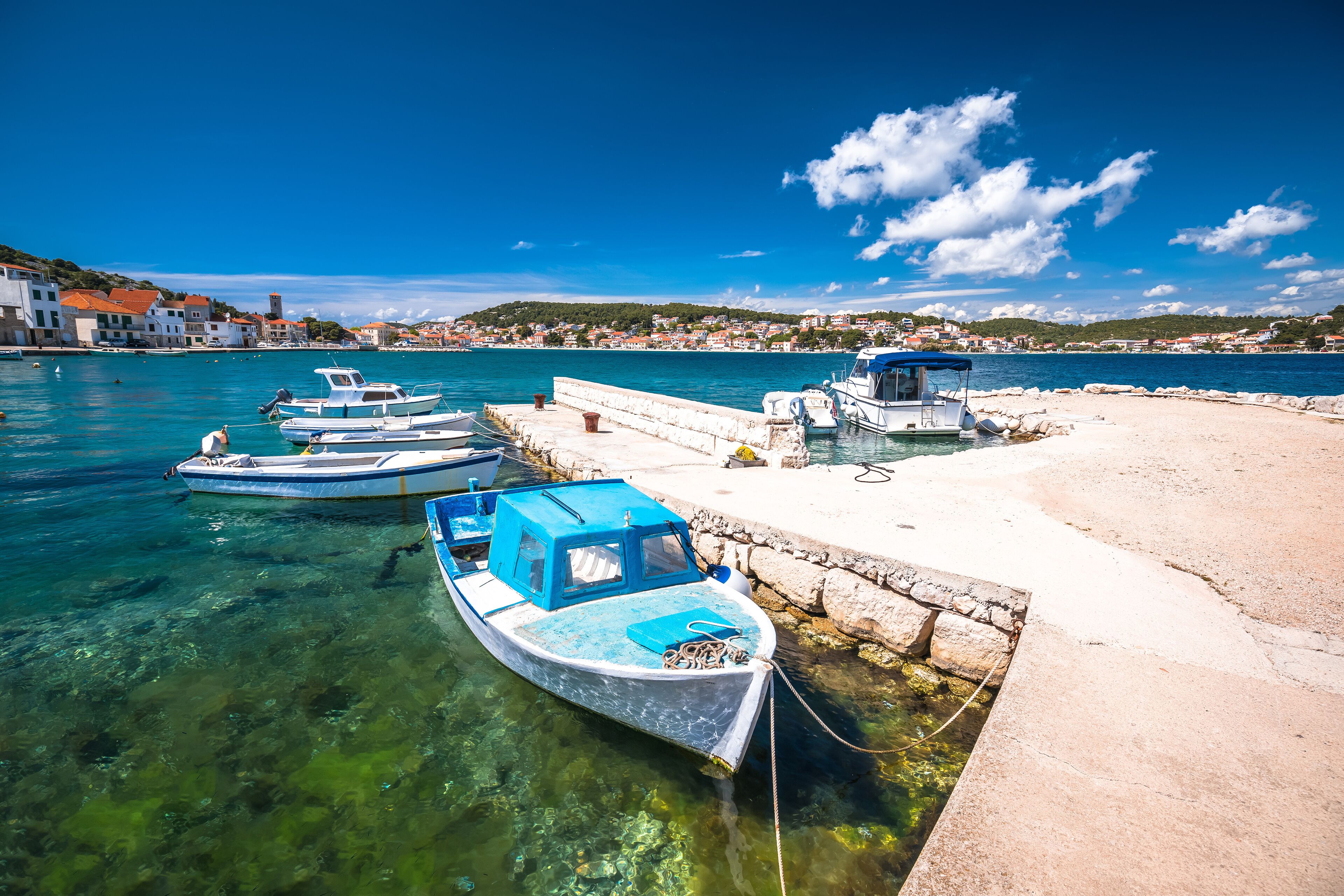 Turquoise coastline and boats in town of Tisno