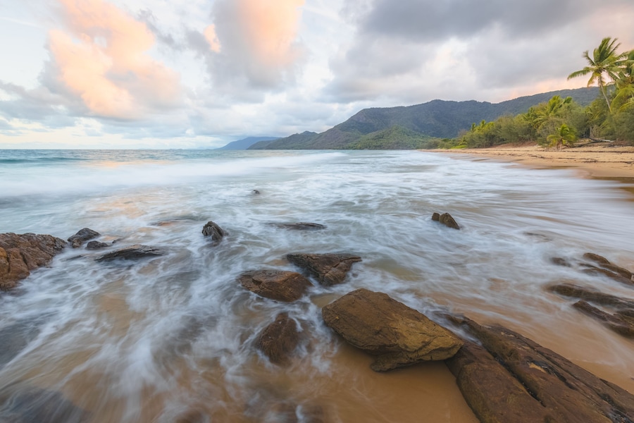 Rocky shoreline on an idyllic, tropical sandy Thala Beach near Oak Beach at sunrise or sunset outside Port Douglas and the Daintree in Queensland, Australia.