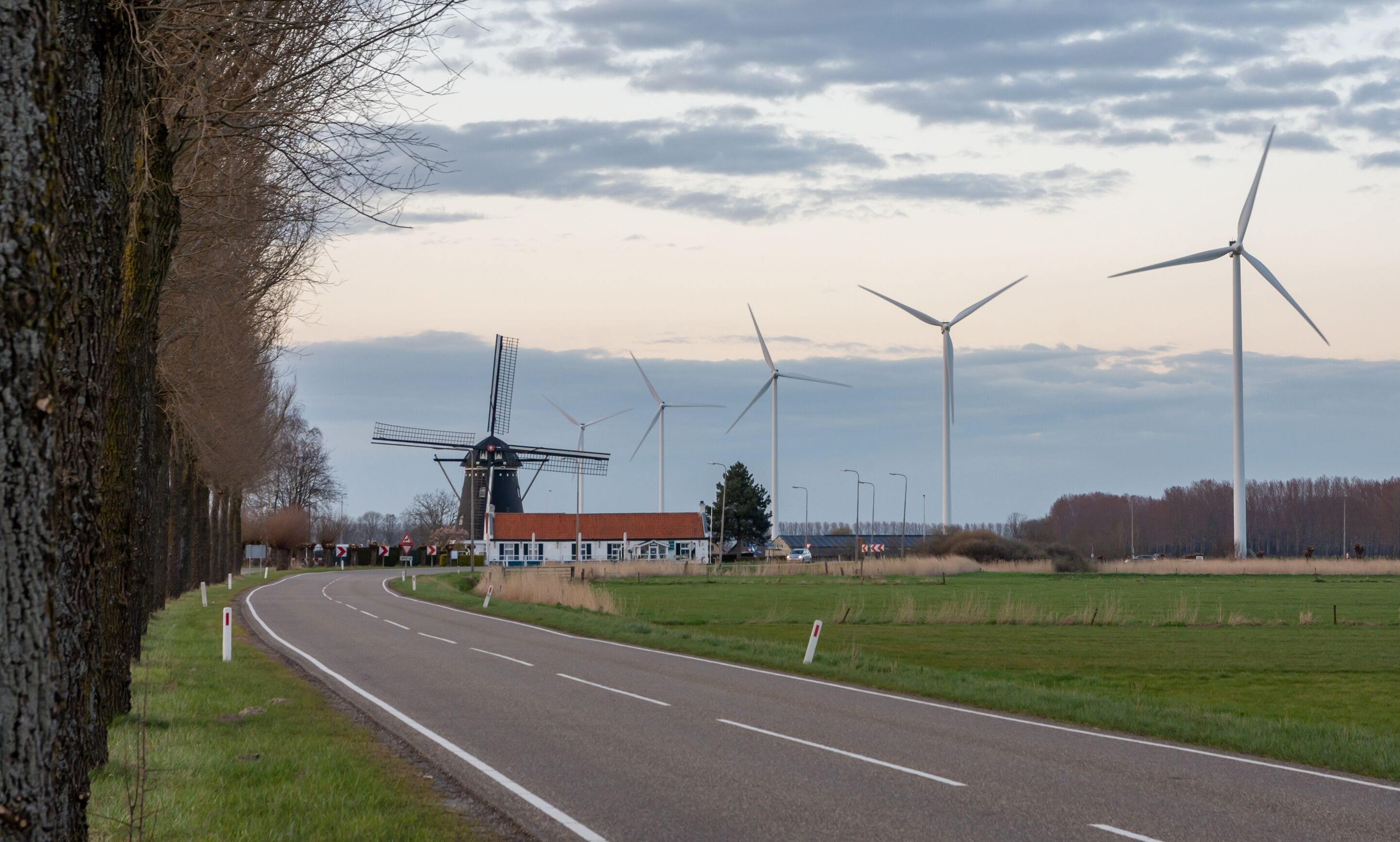 Old and new technology - wind turbines next to the traditional dutch windmill in city of Etten-Leur, The Netherlands