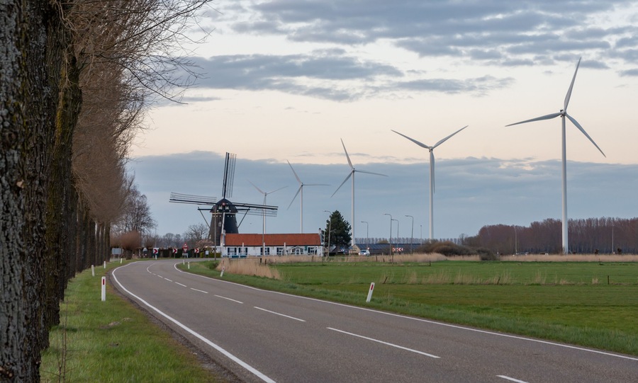Old and new technology - wind turbines next to the traditional dutch windmill in city of Etten-Leur, The Netherlands