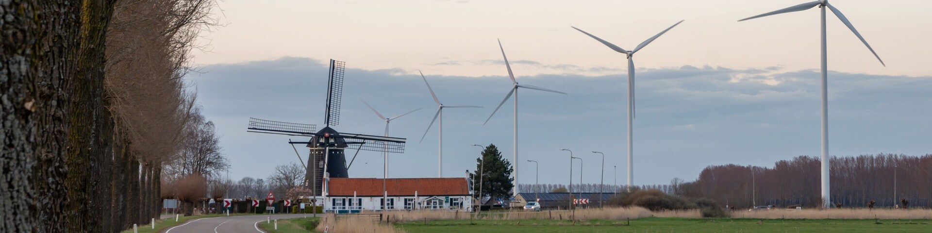 Old and new technology - wind turbines next to the traditional dutch windmill in city of Etten-Leur, The Netherlands