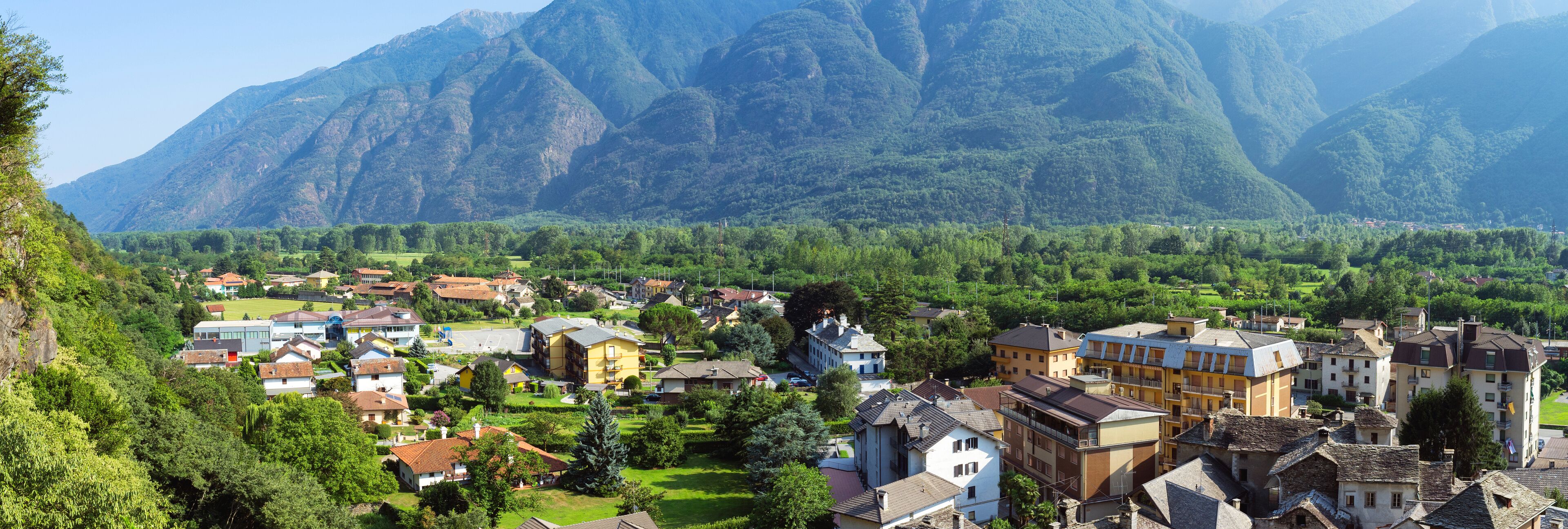 A town nestled in a valley with mountains in the background.