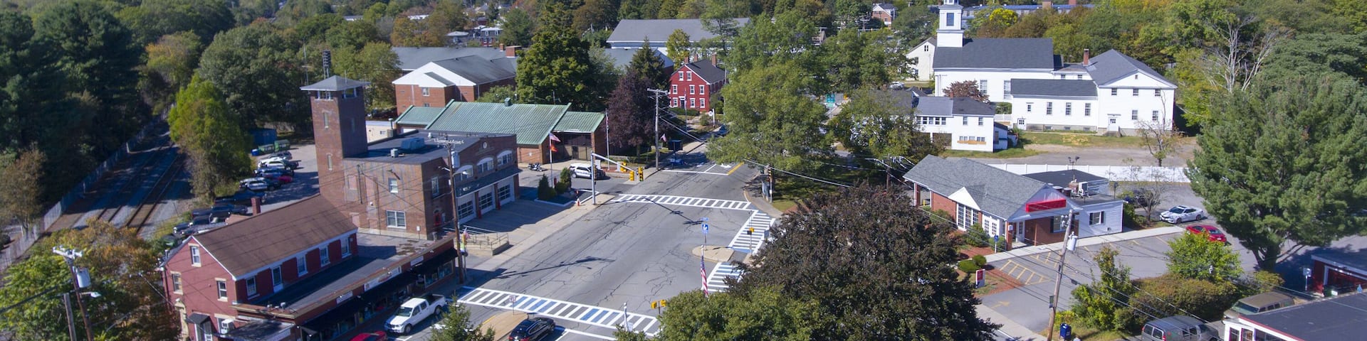 A town with a prominent church, a train station, and a mix of commercial and residential buildings.