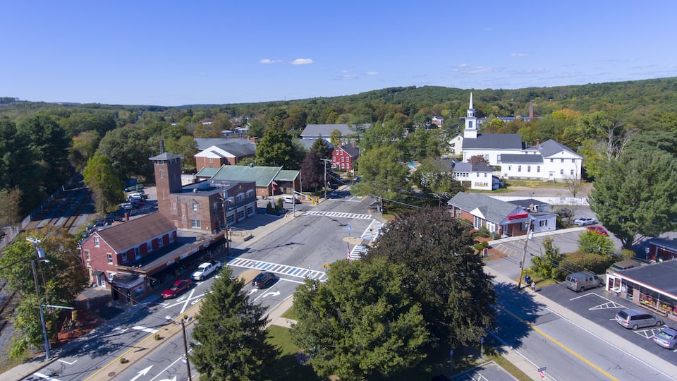 A town with a prominent church, a train station, and a mix of commercial and residential buildings.