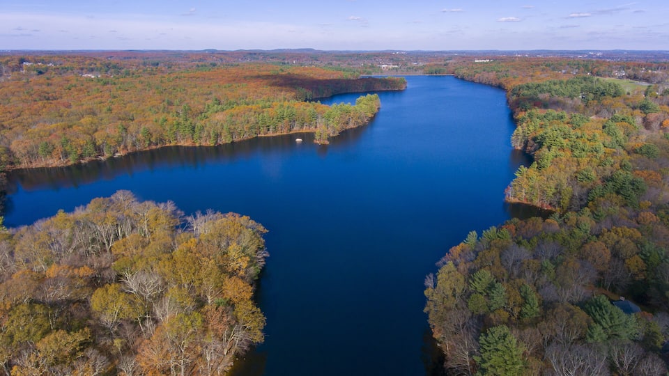 A river winding through a forest with autumn foliage.