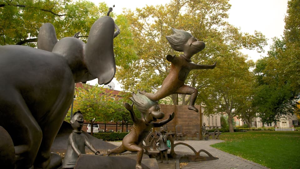A park with bronze sculptures of animals and a building in the background.