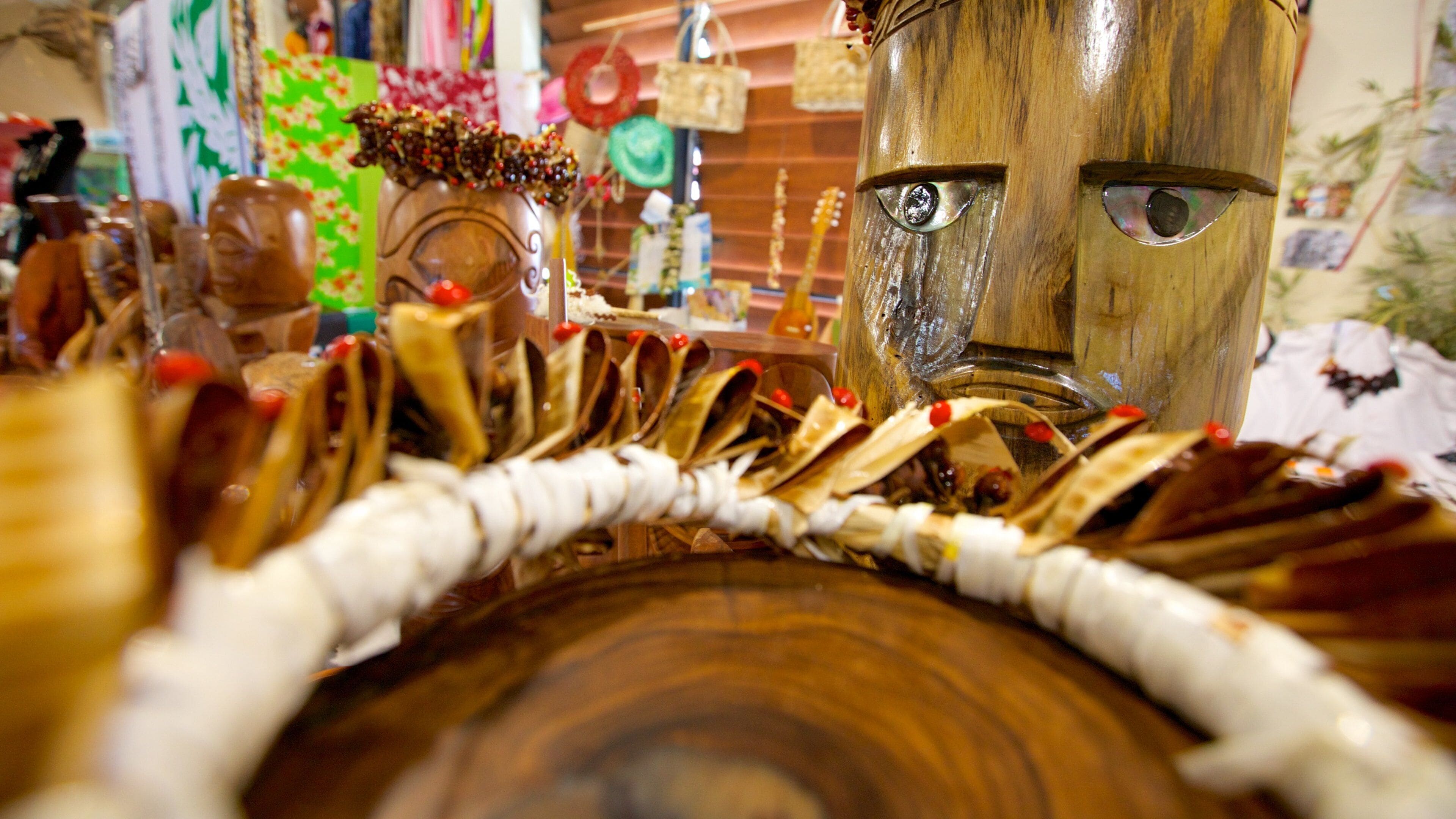 A wooden mask with a carved face, surrounded by various decorative items.