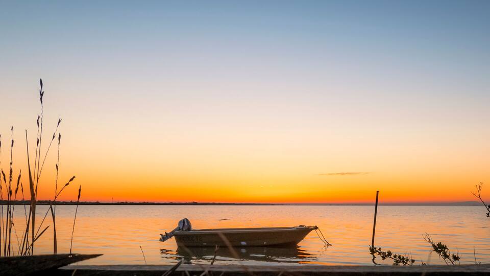 Vue d'un coucher de soleil sur un étang de la Camargue, réserve naturelle protégée