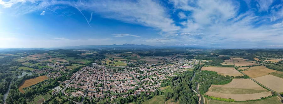 Luchtbeeld van een stad omringd door velden en bergen.