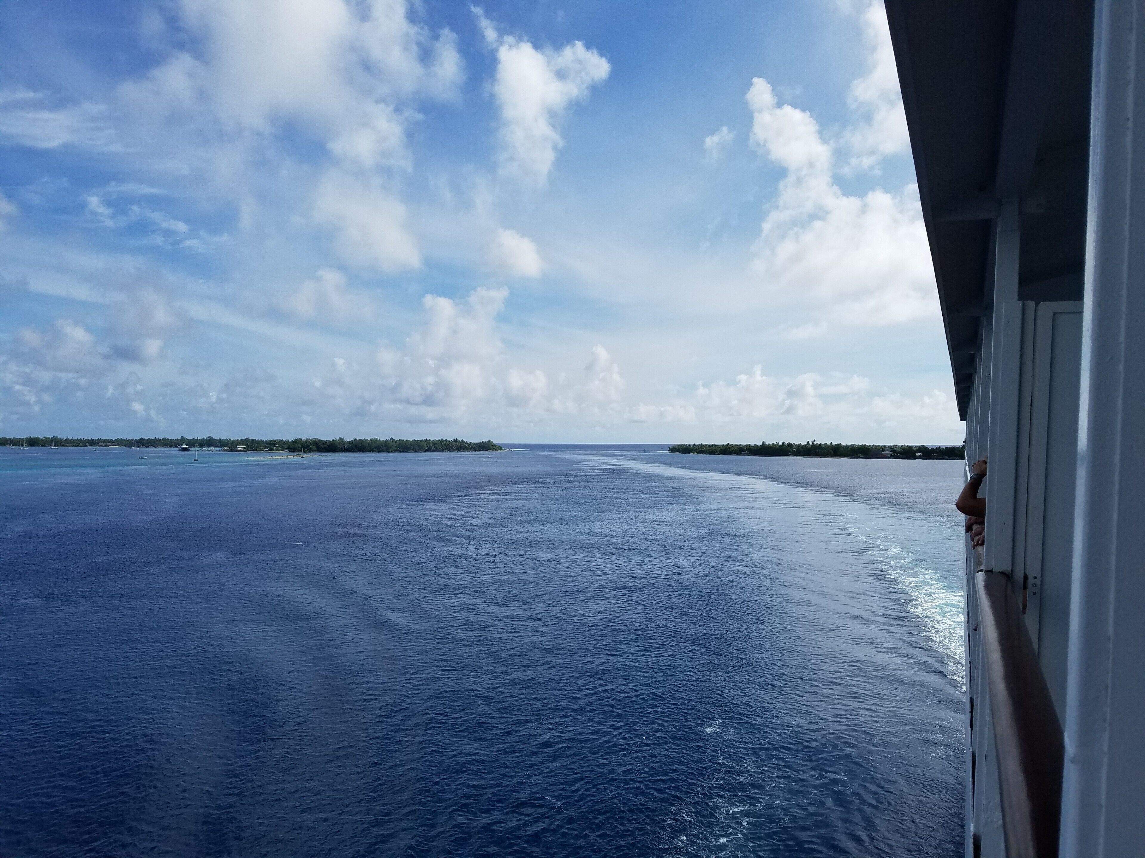 The cruise ship M/S Paul Gauguin is one of few cruise lines to visit Rangiroa, a remote atoll in the Tuamotu Islands of French Polynesia. The atoll is a huge "O", formed by the edge of a narrow volcanic ring that just breaks the surface of the ocean. This image shows the where the ship just passed through a narrow opening in the ring toward an anchorage in the middle of the "O". The inside of the O is so big that you can barely see the surrounding atoll on all sides of you when you're in the  middle.